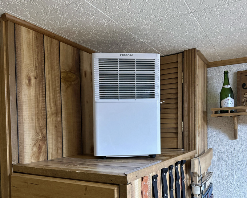 dehumidifier sitting on top of wooden cabinet